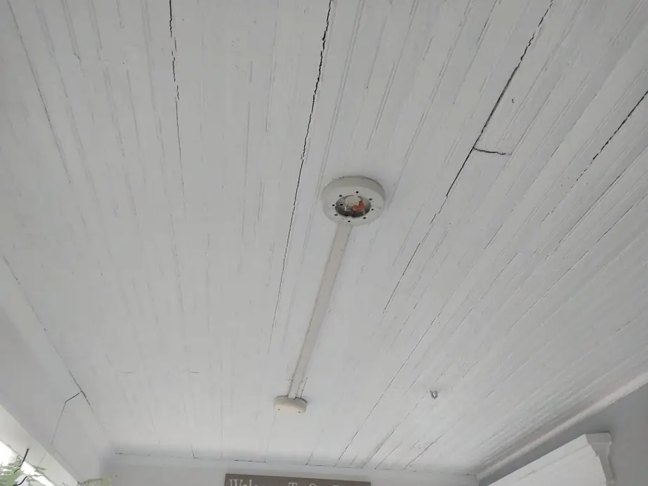 Porch ceiling with a bare light fixture before the fan went up