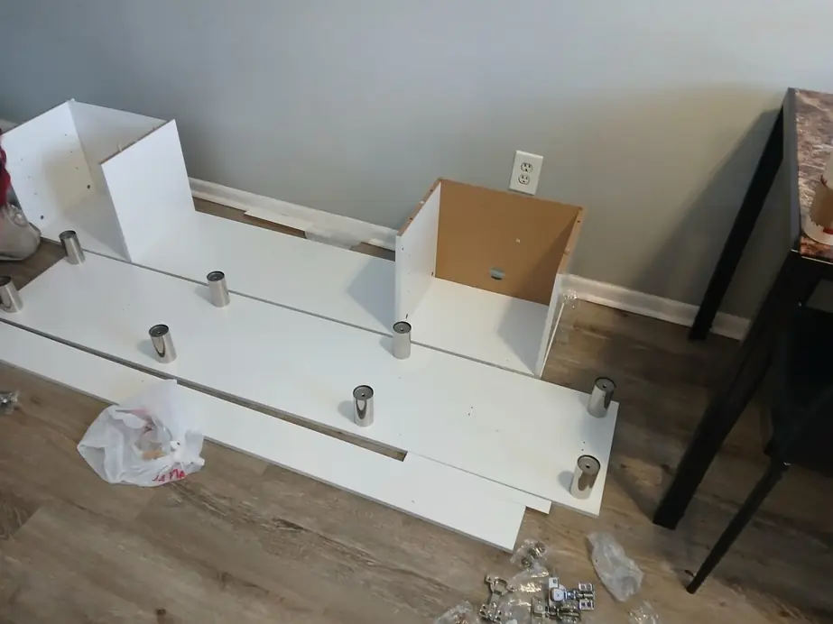 The same console mid-assembly on the floor, panels and hardware laid out